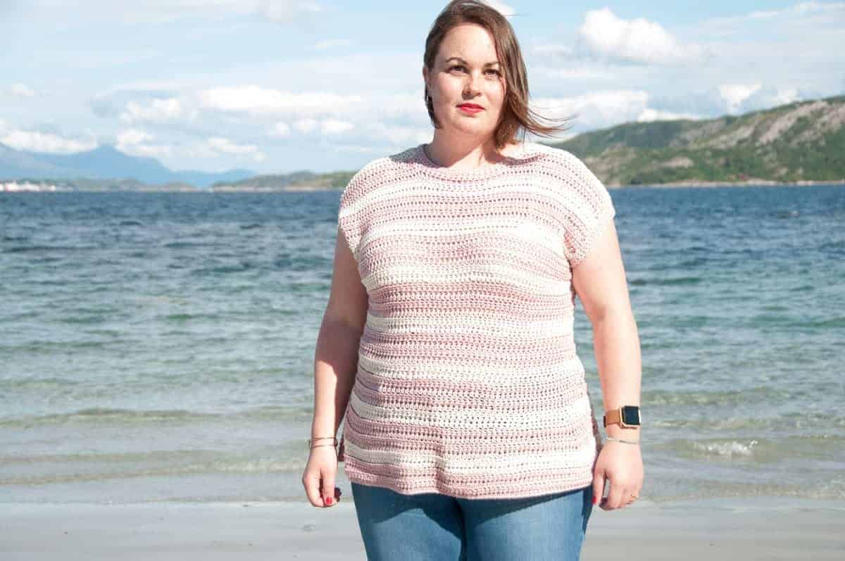 woman wearing a striped crochet tshirt made with white and pink yarn colors