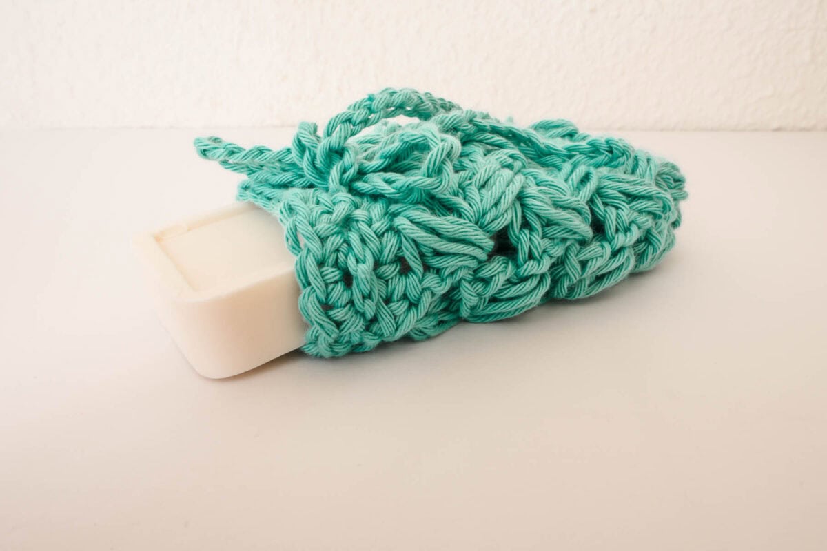crochet soap saver with green yarn and a white bar of soap