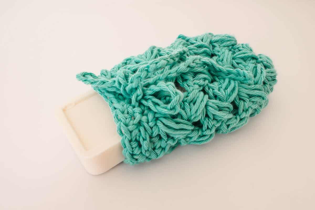 crochet soap saver with green yarn and a white bar of soap