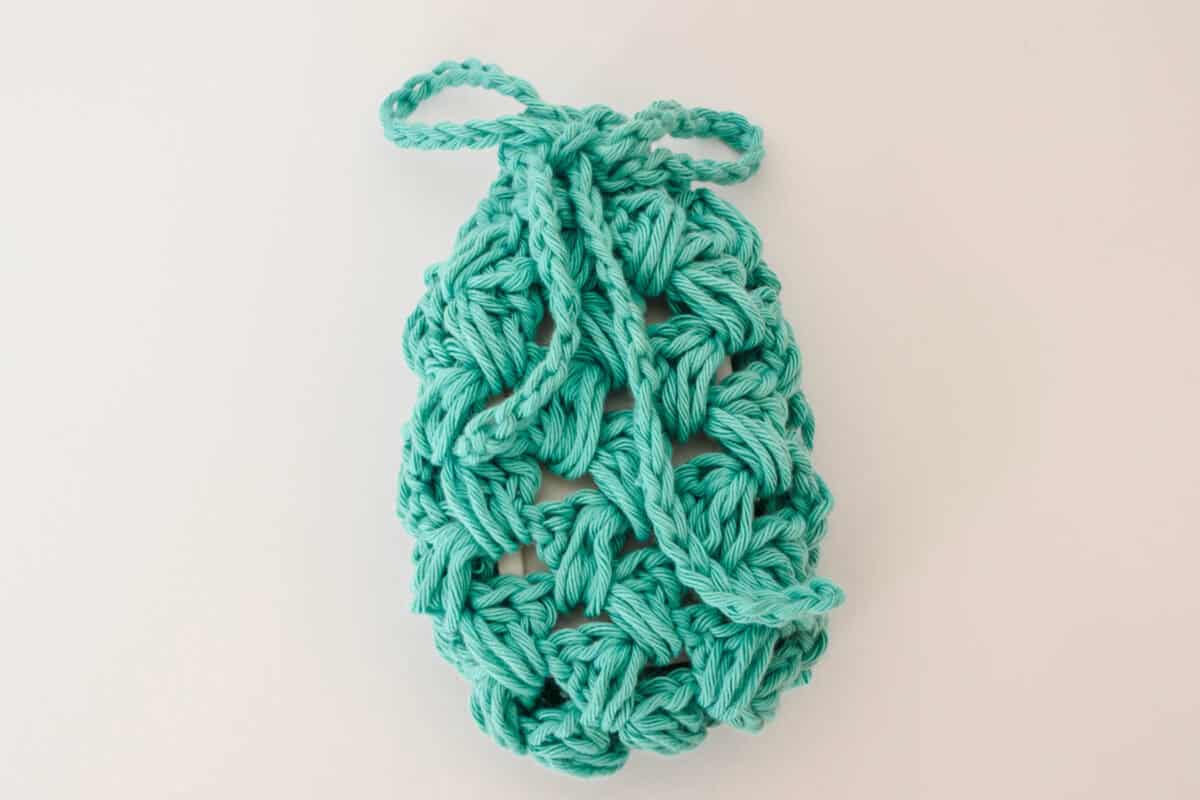 crochet soap saver with green yarn and a white bar of soap