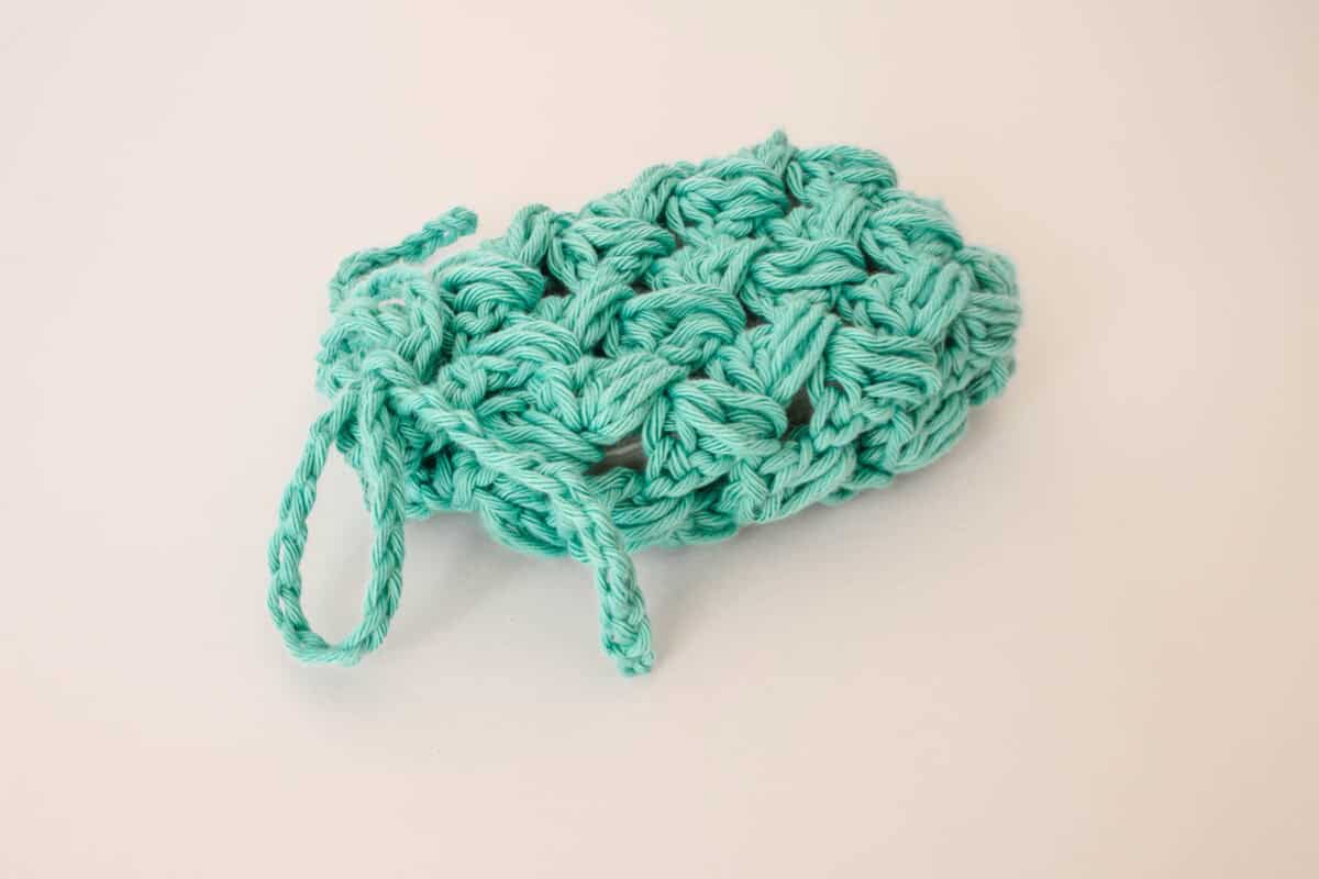 crochet soap saver with green yarn and a white bar of soap